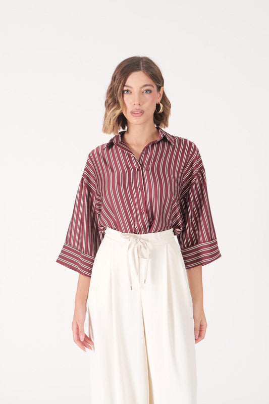 Camicia a righe bordeaux con maniche ampie e pantaloni bianchi eleganti da donna